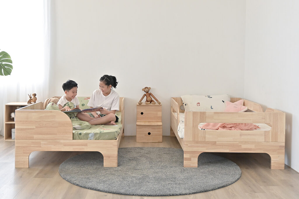 two kids reading book on bed