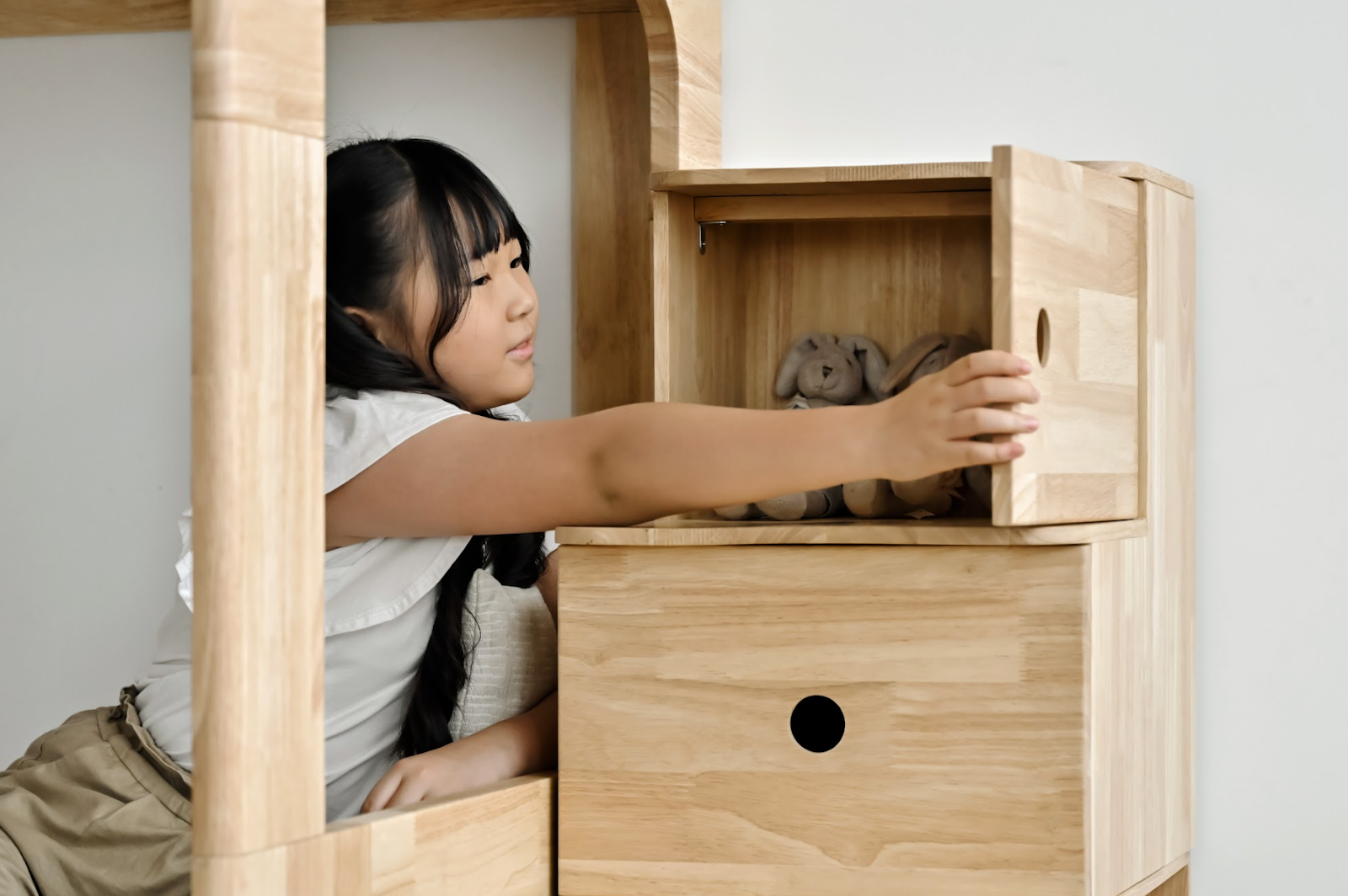 Female child putting plushie into storage
